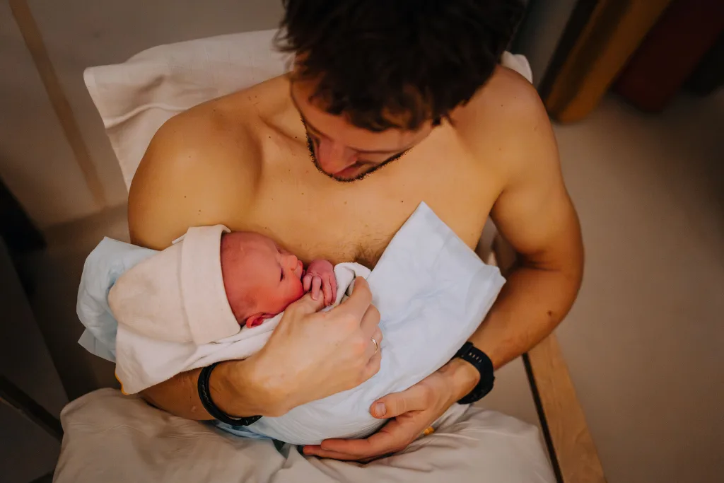 Net geboren baby en knuffelen bij papa